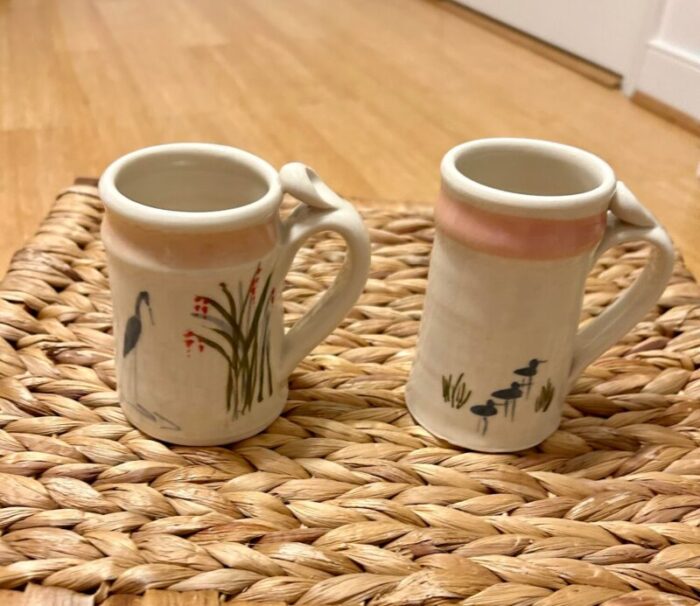 set of 2 jan mann signed and dated tea coffee mugs north carolina pottery with bird scenes stork and egret in soft blues light pink 2322